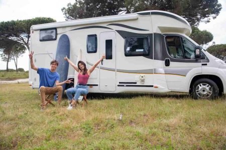 Person inspecting a camper trailer at a dealership, focusing on features and size before making a purchase.