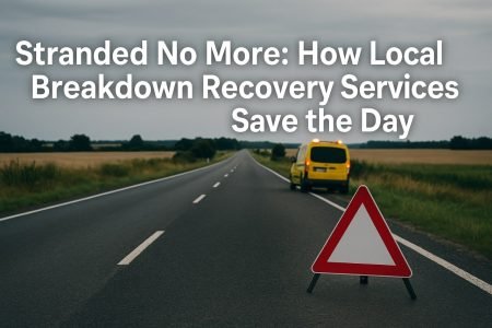 Yellow recovery van and warning triangle on rural road.
