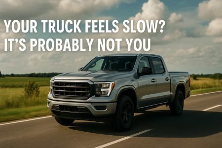Silver pickup truck driving on a rural road under a cloudy sky.