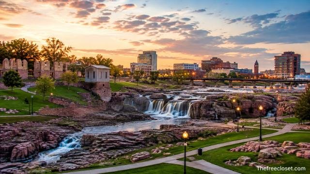 Downtown Sioux Falls skyline and Falls Park waterfalls at sunset.